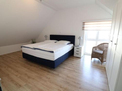 una camera da letto con un letto, una sedia e una finestra di The Molenhuus "Starfish" a Kappeln