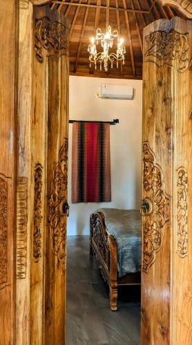 a room with a bed and a chandelier at Samsara Penida in Batununggul