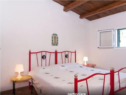 カヴァ・ダリーガにあるSerenity Holiday Homeのベッドルーム1室(赤いベッド1台、テーブル2台、ランプ2つ付)