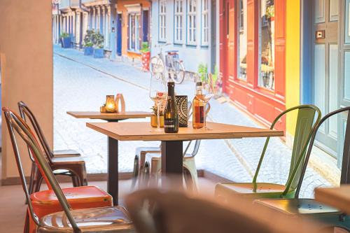 a table with bottles and chairs in a restaurant at Hotel Wilna in Erfurt