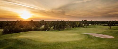a view of a golf course with the sun setting at Komandandi Apartments in Kuressaare