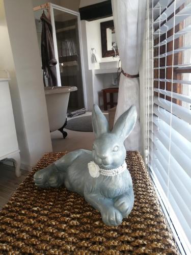 a statue of a rabbit laying on a rug at De Witte Huis in Bethlehem