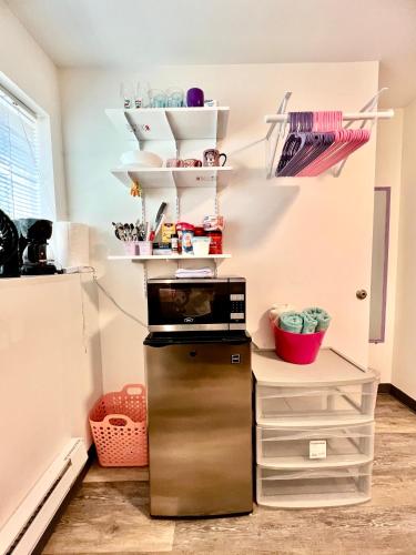 a kitchen with a refrigerator and shelves at Private Room with Shared Bathroom on the 1st Floor 10 Minutes Walk to University of Washington in Seattle