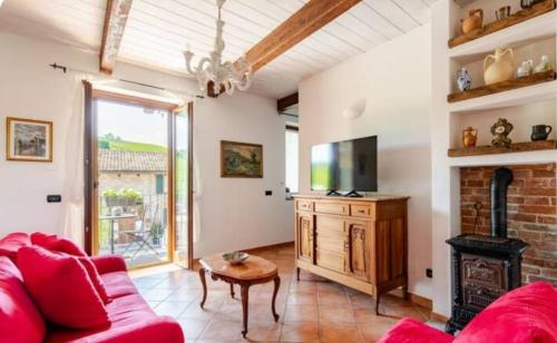 a living room with a red couch and a fireplace at Villa Gallina in Barbaresco