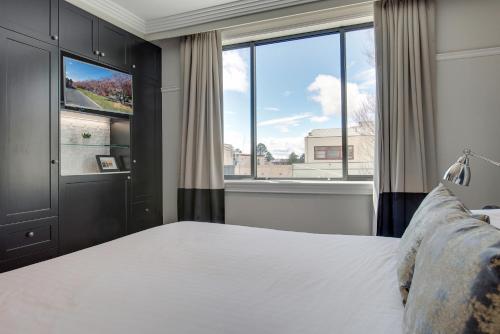 a bedroom with a bed and a large window at Mountain Retreat, Steps from Train Station in Katoomba