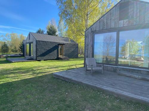a small house with a bench on a lawn at Nina põhumajad in Nina