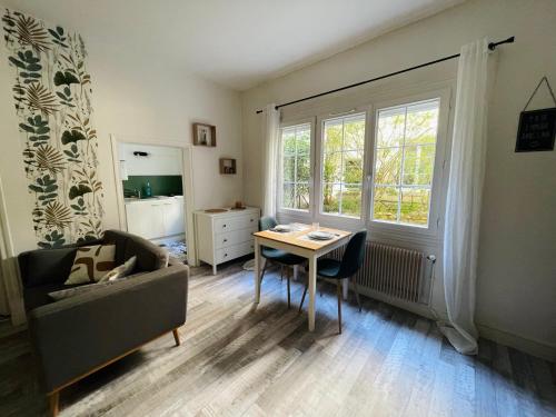 un salon avec un canapé, une table et une fenêtre dans l'établissement Studio Rouen gare proche centre ville, à Rouen