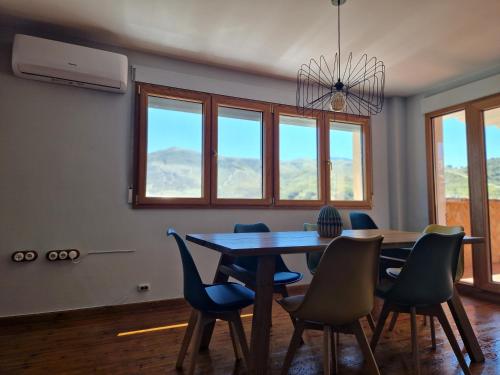 a dining room with a table and chairs and windows at ATICO RIO GENIL in Cenes de la Vega