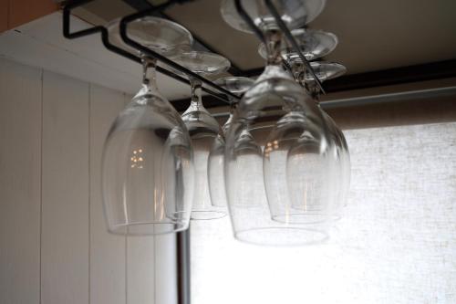 a group of wine glasses hanging from a chandelier at くつろぎのお宿 やわや toyama in Sakurabashidōri