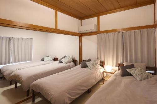 Habitación con 4 camas y ventana en くつろぎのお宿 やわや toyama en Sakurabashidōri