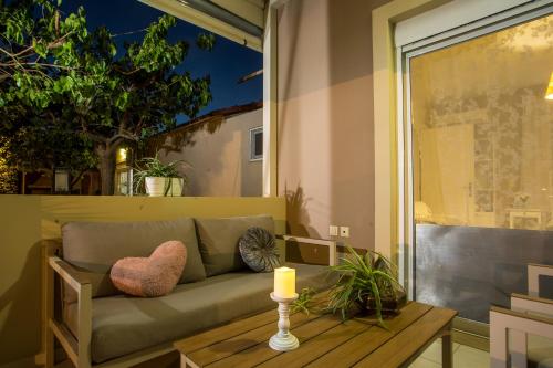 a couch on a balcony with a candle on a table at Sea Breeze & Nature villa ,near the sea, luxury jagguzi and spa private garden in Kremasti