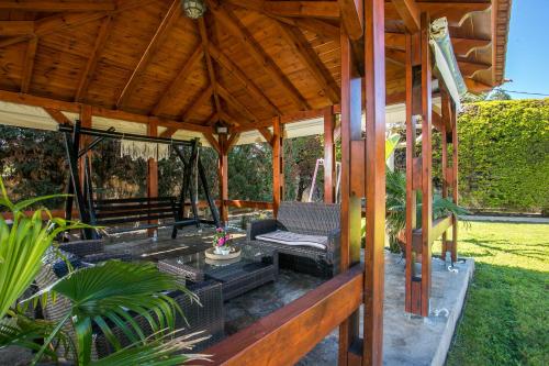 a gazebo with a bench and a swing at Sea Breeze & Nature villa ,near the sea, luxury jagguzi and spa private garden in Kremasti