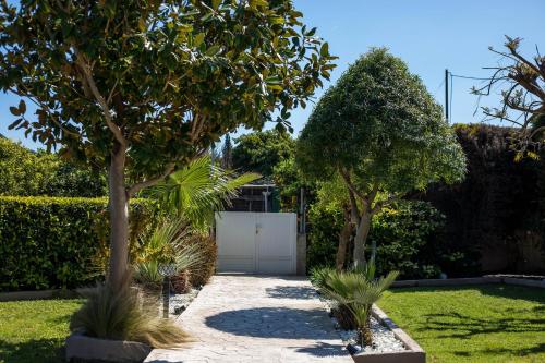 a garden with two trees and a driveway at Sea Breeze & Nature villa ,near the sea, luxury jagguzi and spa private garden in Kremasti