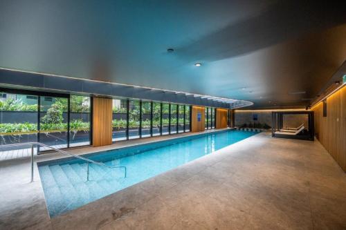 a swimming pool in a building with a large window at Luxury Melbourne 4 Bed Apt - Pool and Parking in Melbourne