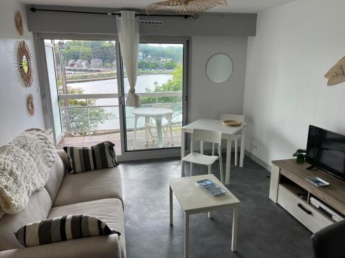 un salon avec un canapé et une table dans l'établissement Studio vue mer sur le port de Perros-Guirec, à Perros-Guirec
