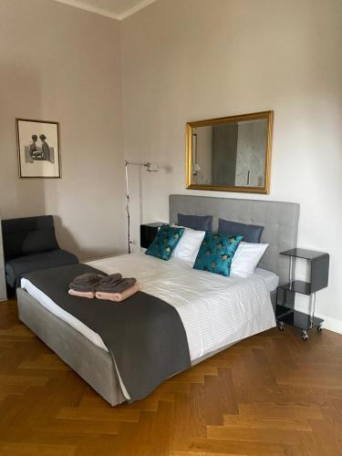 una camera con un grande letto e uno specchio di Acquaviva Apartments a Livorno