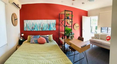 een slaapkamer met een bed en een rode muur bij 29b Casa DeGregory, In the heart of Parap in Parap