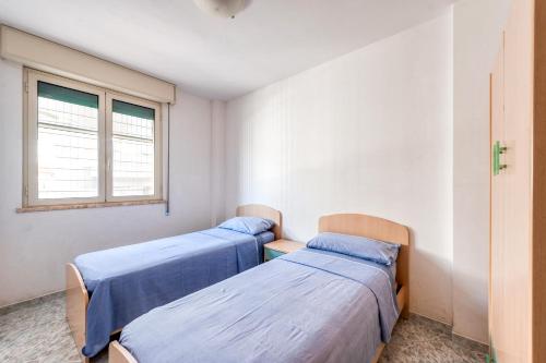twee bedden in een ziekenhuiskamer met een raam bij Carlo in San Pietro in Bevagna
