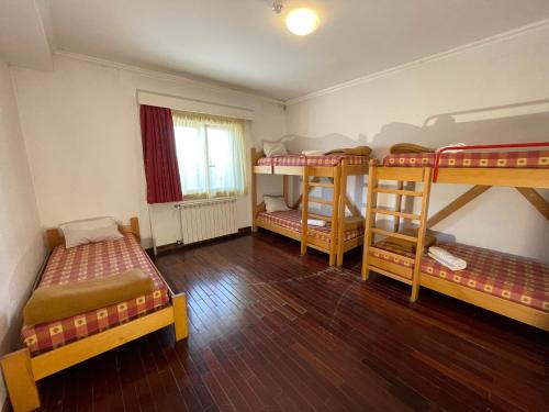 a room with three bunk beds and a window at HI Bragança – Pousada de Juventude in Bragança