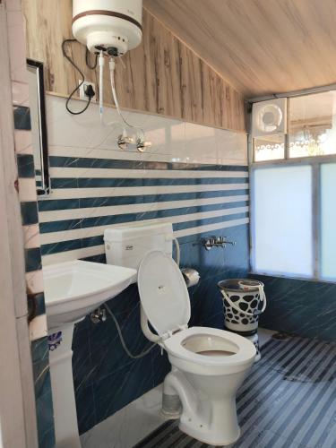 a small bathroom with a toilet and a sink at Gulab - B Homestay in Dehradun