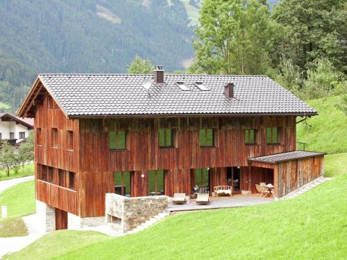 a large wooden building on top of a green hill at Apartment in Ramsau im Zillertal with sauna in Ramsau im Zillertal