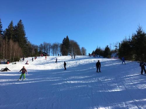 a group of people skiing down a snow covered slope at Gîte à 10min du circuit de Spa-Francorchamps in Jalhay