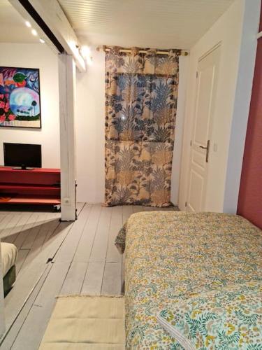a bedroom with a bed and a flat screen tv at La parenthèse maison de vacances à Hauterives in Hauterives