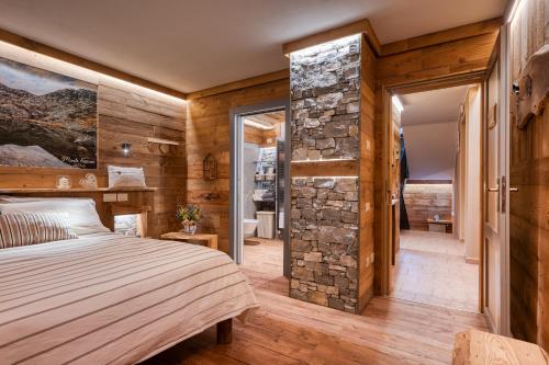a bedroom with a bed and a stone wall at L'Arbergh Palanfrè in Vernante