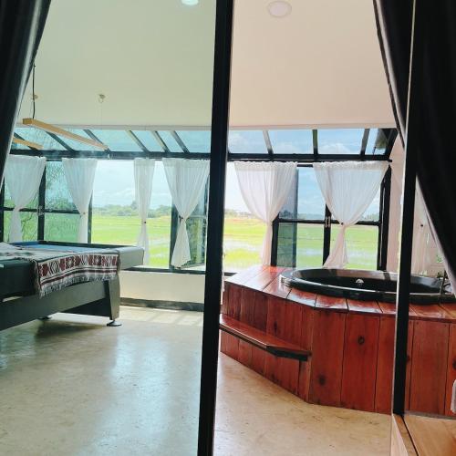 a room with two beds and a large window at Penguin Villa Resort & Bistro in Ratchaburi