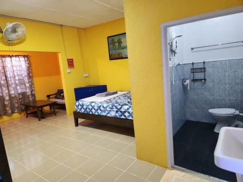 y baño con cama, ducha y lavabo. en Gecko Guesthouse, en Pantai Cenang