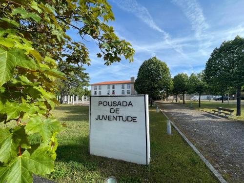 a sign in the grass in front of a building at HI Bragança – Pousada de Juventude in Bragança