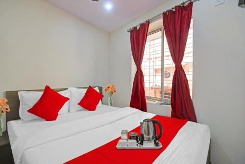 1 dormitorio con cama blanca y almohadas rojas en GRG Vhyom Sky Palace Near Metro Station Kolkata, en Calcuta