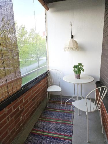 a patio with two chairs and a table and a window at City Apartment with Lakeview in Iisalmi in Iisalmi