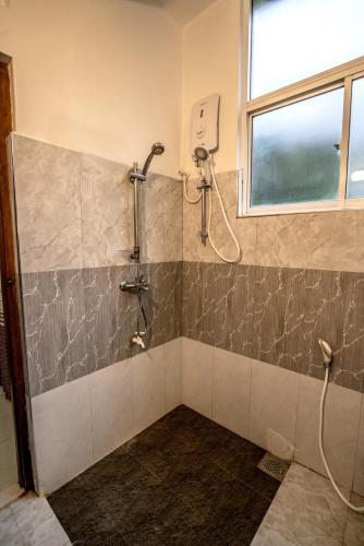 a shower stall in a bathroom with a window at The KANDY DOWNTOWN Maroon House in Katugastota