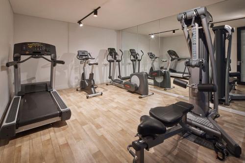 a gym with several treadmills and exercise bikes at Kennigo Hotel Brisbane, Independent Collection by EVT in Brisbane
