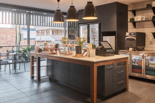 a kitchen with a counter with food on it at Kennigo Hotel Brisbane, Independent Collection by EVT in Brisbane