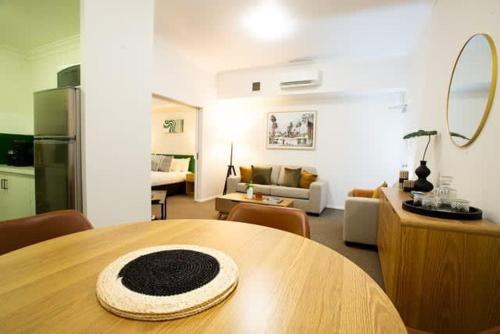 a room with a table and a living room at Fully Renovated 1Bdr Apt in Northbridge in Perth
