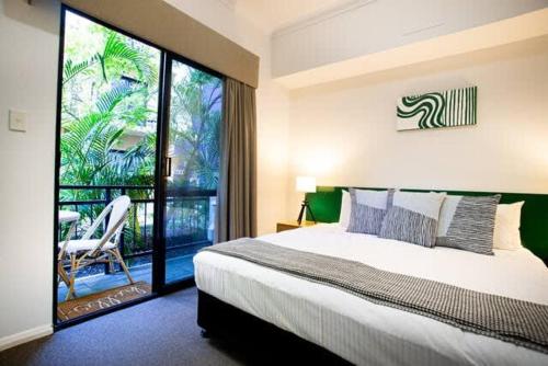 a bedroom with a large bed and a sliding glass door at Fully Renovated 1Bdr Apt in Northbridge in Perth