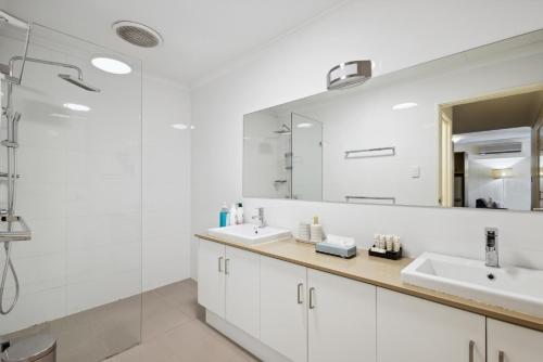 a bathroom with two sinks and a large mirror at Spacious Apt in Northbridge with Pool in Perth