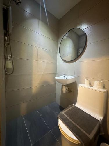 a bathroom with a toilet and a sink and a mirror at D'Garden Hotel Kuala Lumpur in Kuala Lumpur