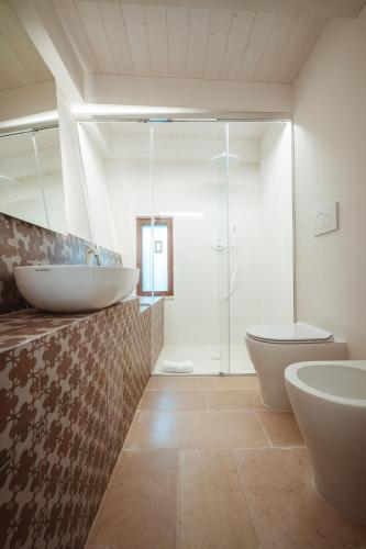 a bathroom with two sinks and a toilet and a shower at TrulloMare Villa Sea View & Pool - Housea in Polignano a Mare