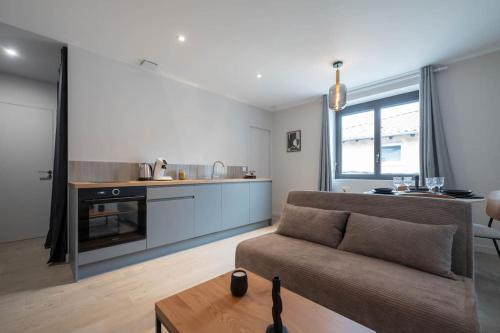 a living room with a couch and a kitchen at L'Opéra, T2 Cœur Ville in Anse