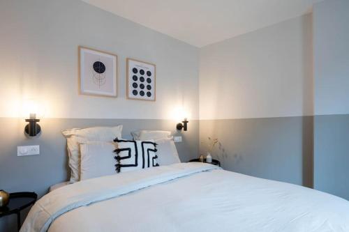 a bedroom with a large white bed with two pillows at L'Opéra, T2 Cœur Ville in Anse