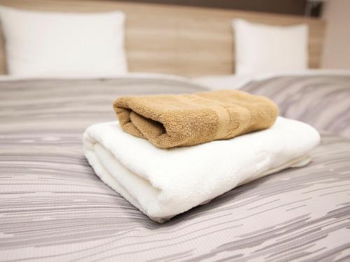 Postel nebo postele na pokoji v ubytování Hotel Route-Inn Shinjyo Ekimae