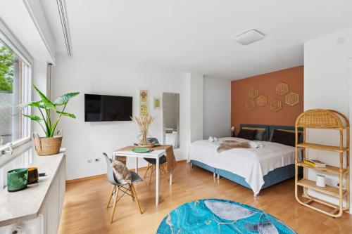 a bedroom with a bed and a table with a chair at Sali Homes SM13 -1-Room Apartment by Röhrensee in Bayreuth