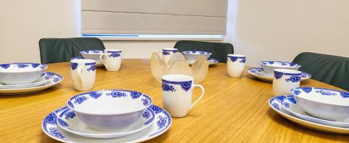 a wooden table with blue and white cups and saucers at Mogul Tower Apartment, UB center in Ulaanbaatar