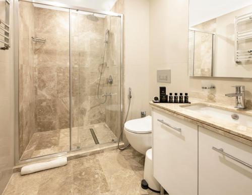 y baño con ducha, aseo y lavamanos. en Mayar Residence Hotel en Estambul
