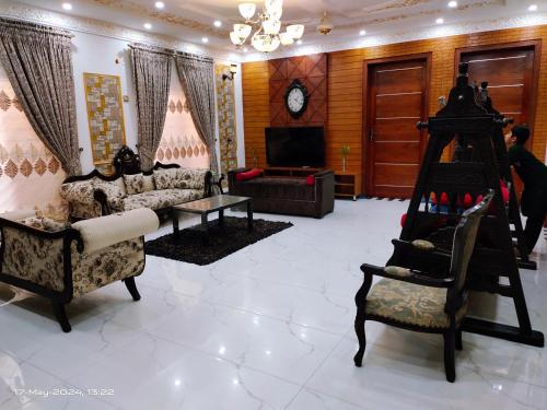 a living room with couches and a tv and a chair at 2 bedroom Independent house Valencia town Lahore in Lahore