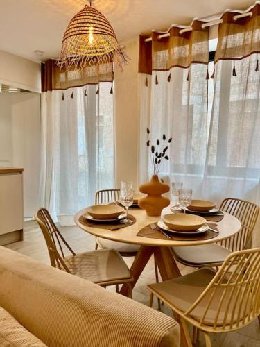 a dining room with a table and chairs and a couch at La Madeleine, T2 Cœur Ville in Anse