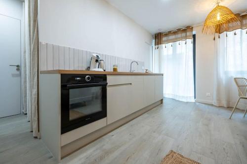a kitchen with a sink and a stove at La Madeleine, T2 Cœur Ville in Anse
